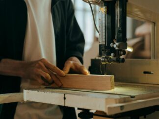 Person in White Long Sleeve Shirt Using Black Sewing Machine